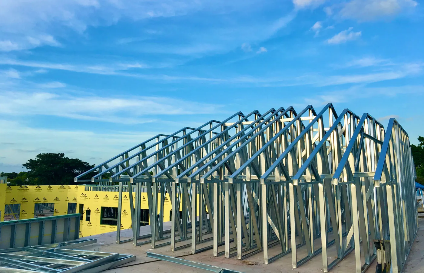 Row of galvanized cold-formed steel roof trusses set on a building